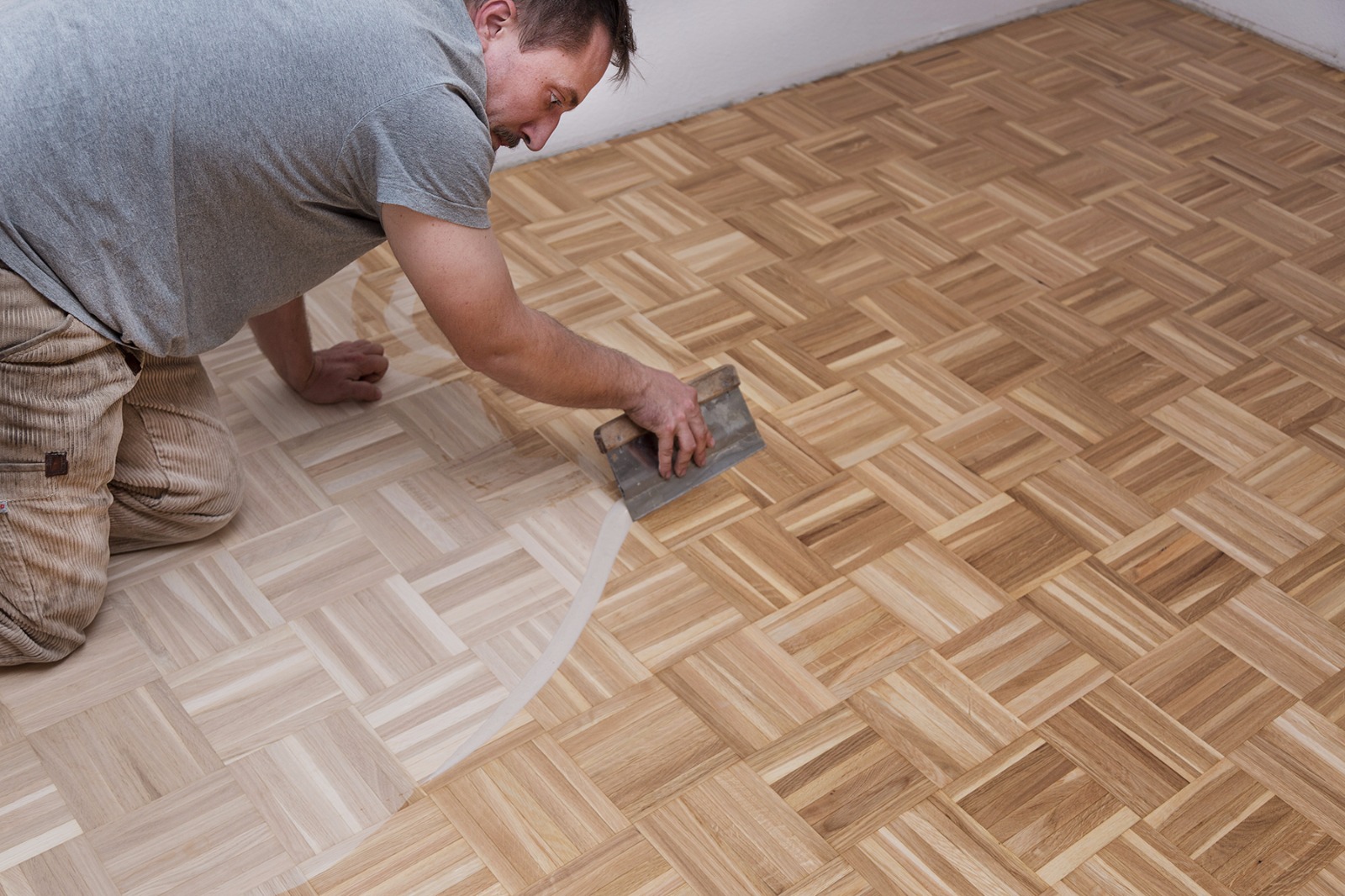 Auftragen eines Oberflächenmittels auf Mosaikparkett